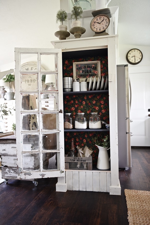 DIY Rustic window cabinet - so easy to build! This cabinet would be great in any room of the house for pretty storage. A great idea to add wrapping paper to the back of the cabinet for a pop of color. 