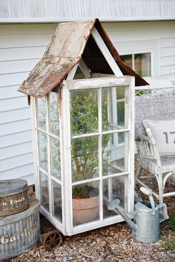 DIY window greenhouse - See how to make this amazing rustic greenhouse. A super easy DIY project that adds rustic charm indoors or outdoors. A great pin for DIY farmhouse decor! 