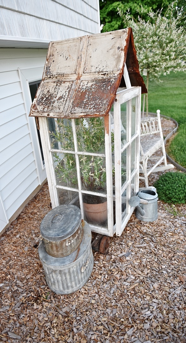 DIY window greenhouse - See how to make this amazing rustic greenhouse. A super easy DIY project that adds rustic charm indoors or outdoors. A great pin for DIY farmhouse decor! 