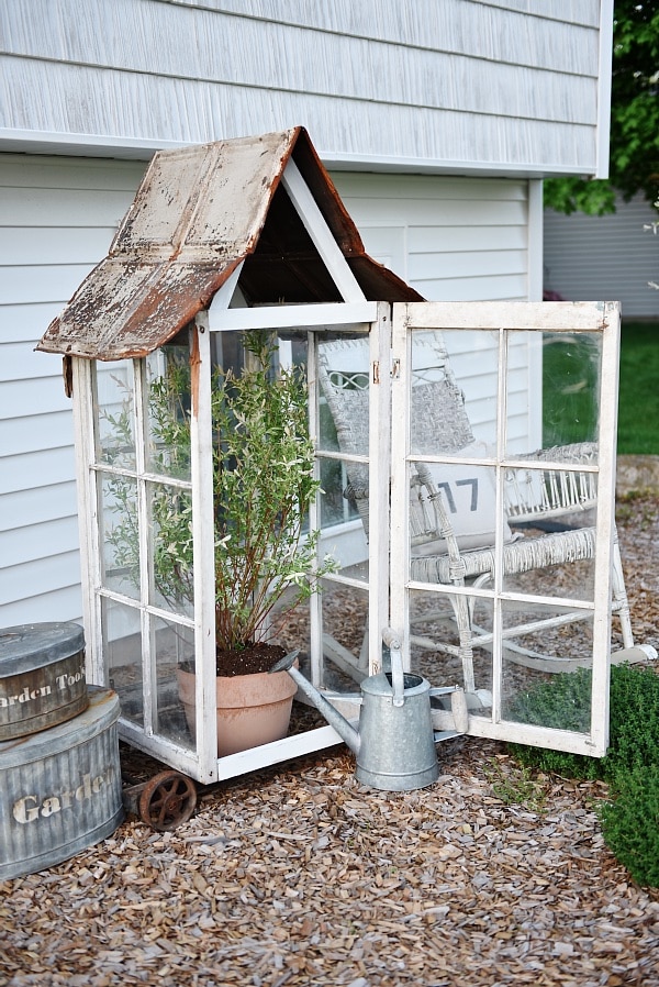 DIY window greenhouse - See how to make this amazing rustic greenhouse. A super easy DIY project that adds rustic charm indoors or outdoors. A great pin for DIY farmhouse decor! 