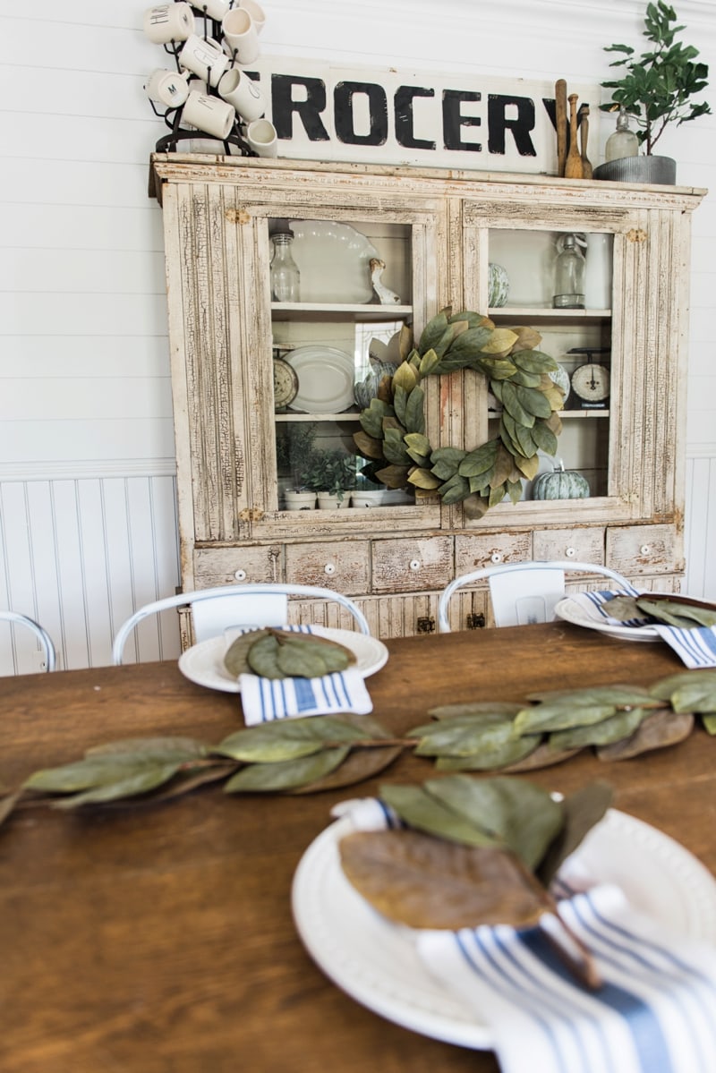 Primitive dining room hutch. Neutral farmhouse dining room. Shiplap walls, primitive furniture, magnolia wreaths, & so much more. Great pin for cottage style/farmhouse style inspiration. 