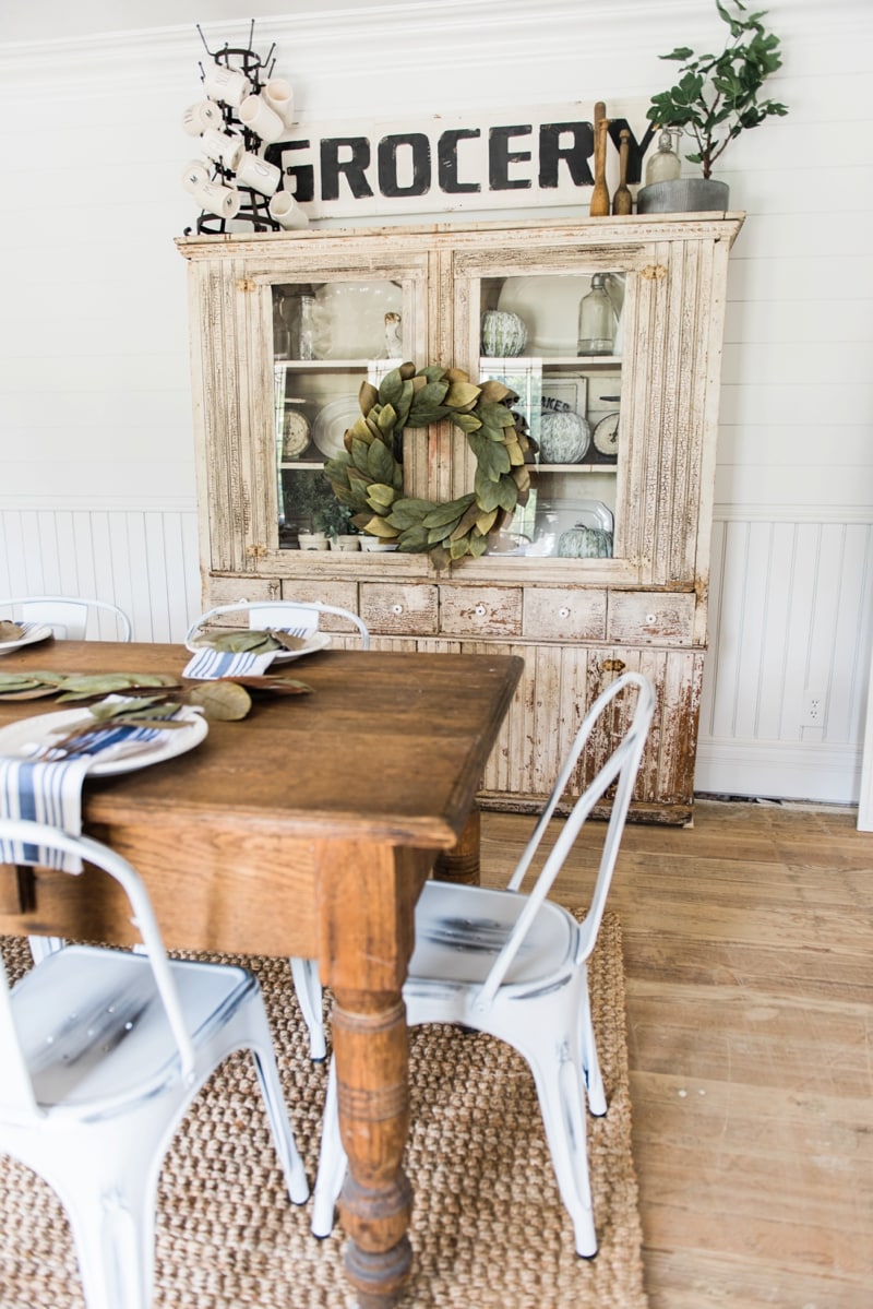 Primitive dining room hutch. Neutral farmhouse dining room. Shiplap walls, primitive furniture, magnolia wreaths, & so much more. Great pin for cottage style/farmhouse style inspiration. 