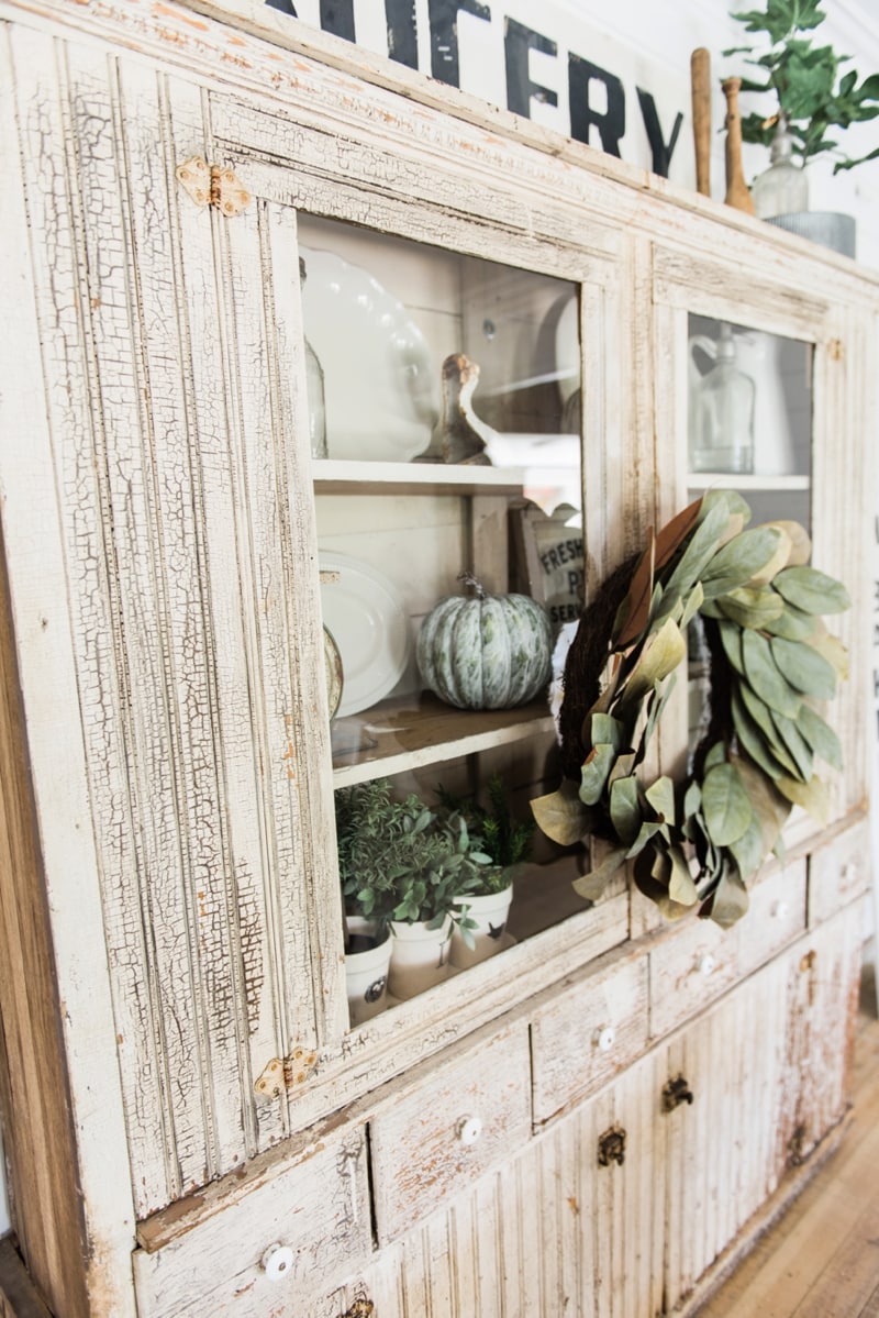 Primitive dining room hutch. Neutral farmhouse dining room. Shiplap walls, primitive furniture, magnolia wreaths, & so much more. Great pin for cottage style/farmhouse style inspiration. 