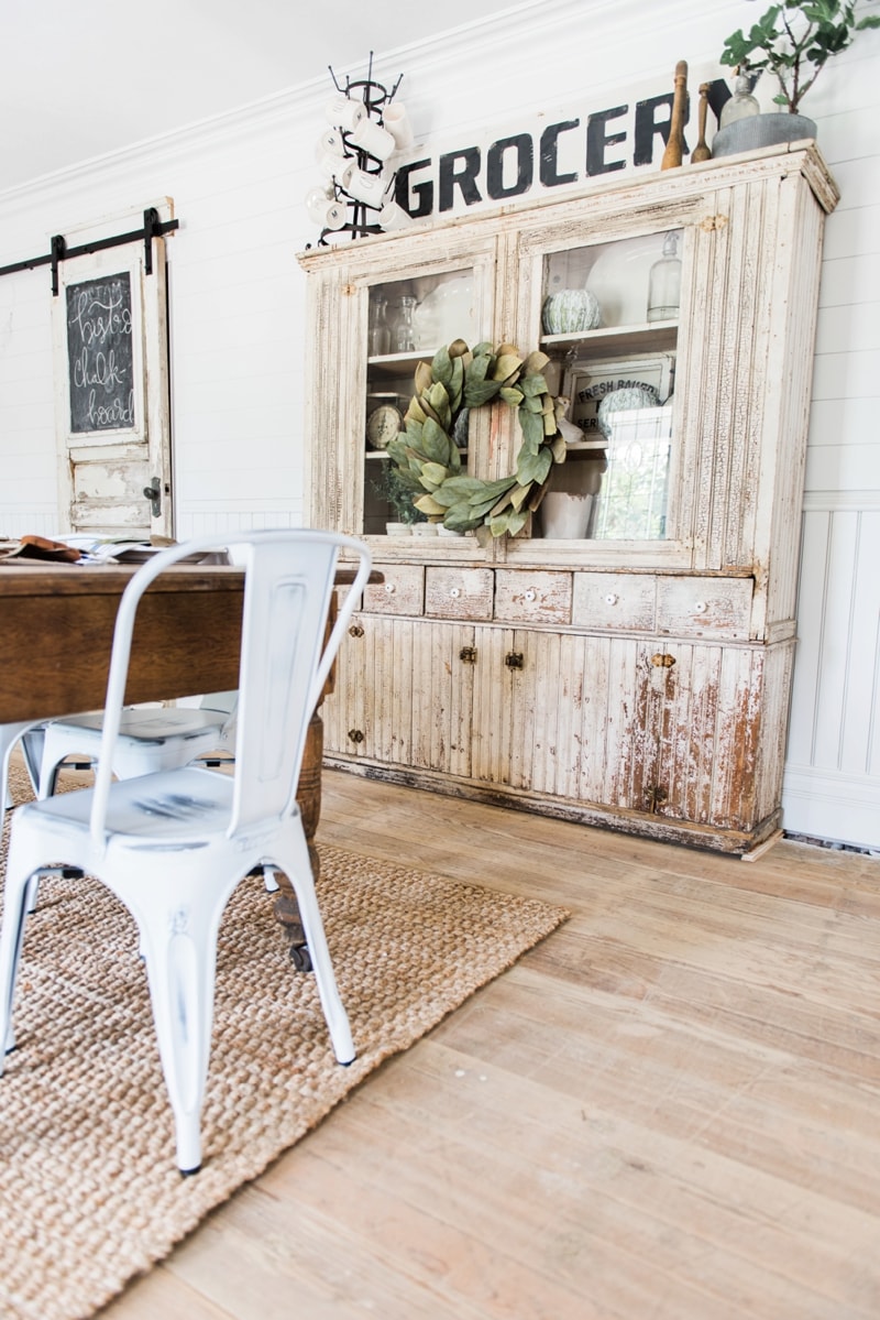Primitive dining room hutch. Neutral farmhouse dining room. Shiplap walls, primitive furniture, magnolia wreaths, & so much more. Great pin for cottage style/farmhouse style inspiration. 