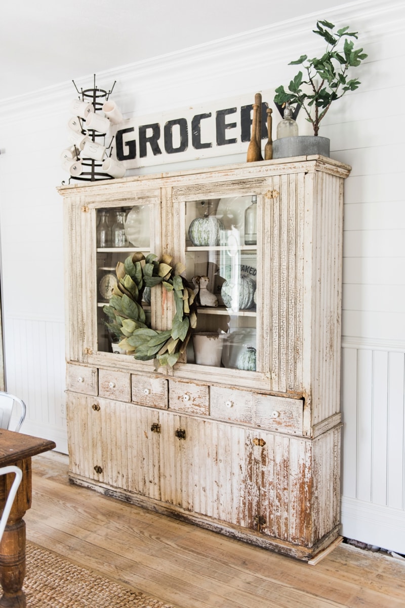 Primitive dining room hutch. Neutral farmhouse dining room. Shiplap walls, primitive furniture, magnolia wreaths, & so much more. Great pin for cottage style/farmhouse style inspiration. 
