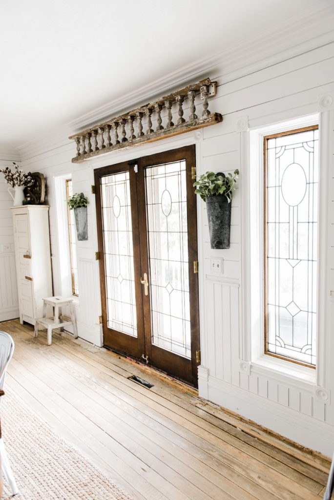 Hanging metal vases with flowers hanging on each side of the french doors. Great farmhouse decor style tips & tricks. A must pin for cottage style and farmhouse style decor. Metal flower vases from Magnolia Market 