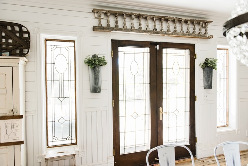 Hanging metal vases with flowers hanging on each side of the french doors. Great farmhouse decor style tips & tricks. A must pin for cottage style and farmhouse style decor. Metal flower vases from Magnolia Market 
