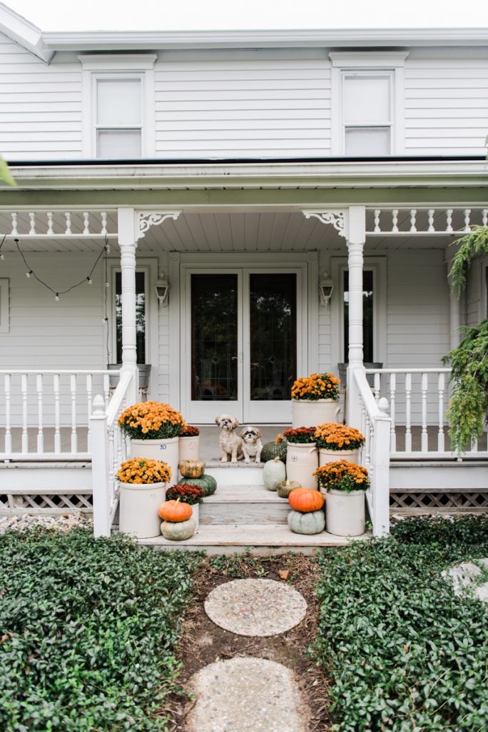Cozy Rustic Fall porch - Mums in crocks to give a farmhouse porch an instant fall vibe. Great source for farmhouse decor. 