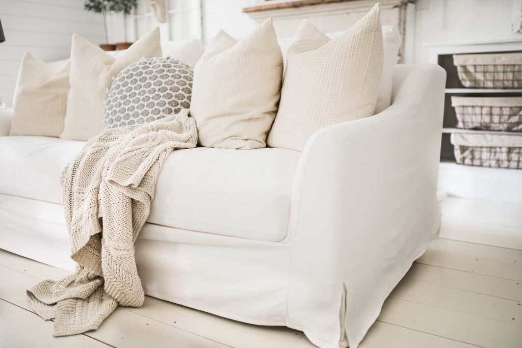 A sofa with white farmhouse slipcovers 