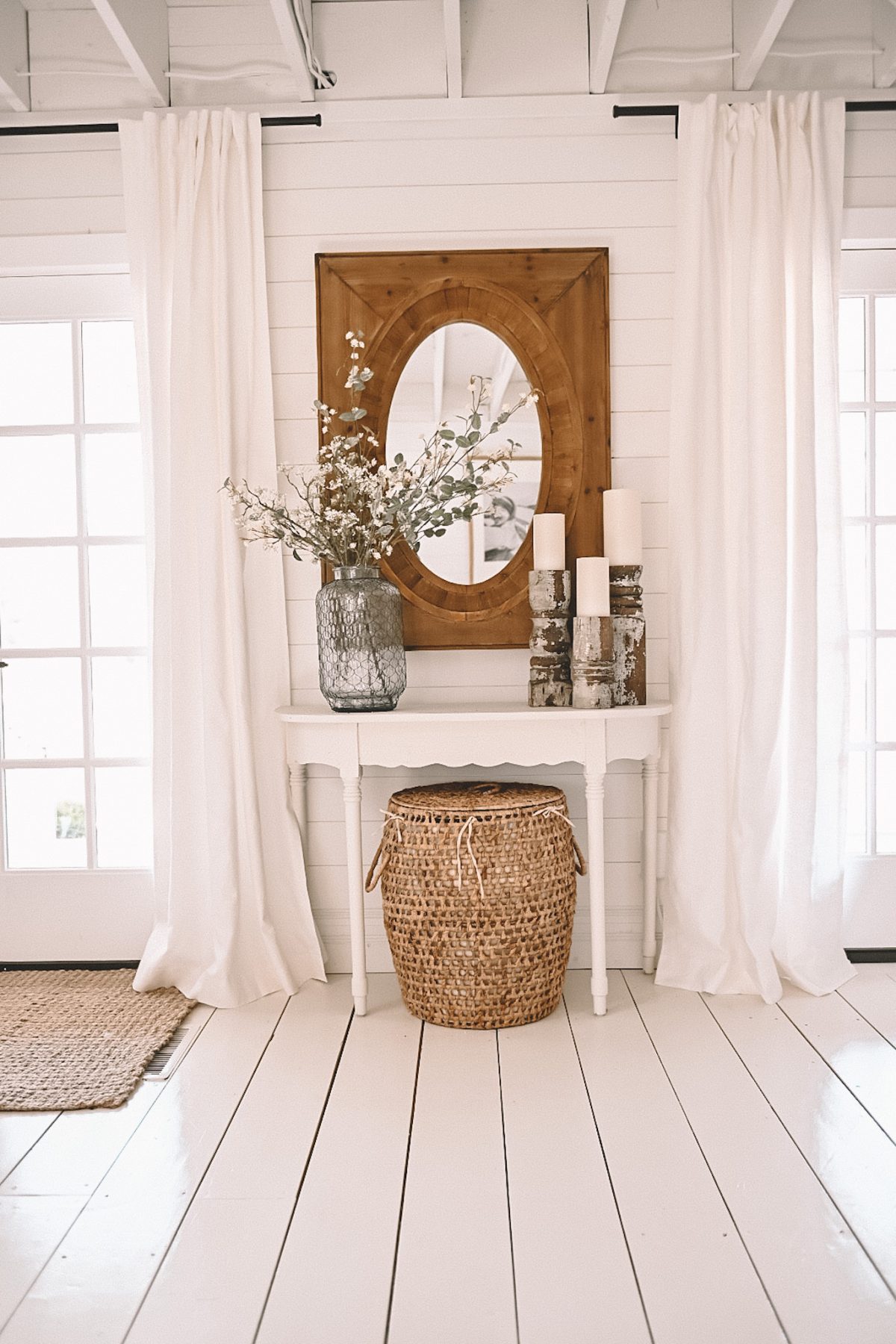 A farmhouse with white flooring displaying an entryway table 