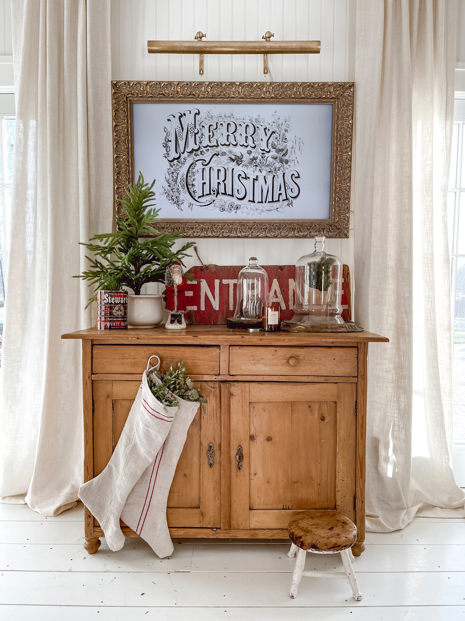 Samsung Frame TV with Merry Christmas Art above Antique Pine Dresser with Christmas Items.
